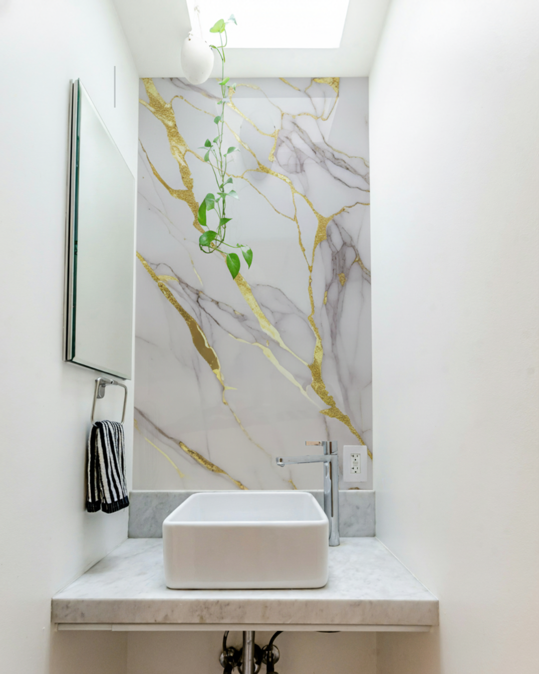 Revêtement mural en PVC appliqué a une salle de bain blanc et or et gris 