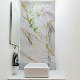 Revêtement mural en PVC appliqué a une salle de bain blanc et or et gris 