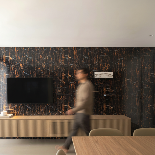 Panneaux en PVC effet Marbre - Noir veine cuivré sur le mur d'un Salon