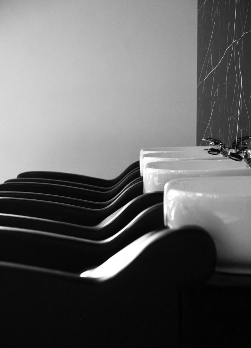 Un panneau en PVC effet marbre noir veiné blanc et or dans un salon de coiffure et de bien être